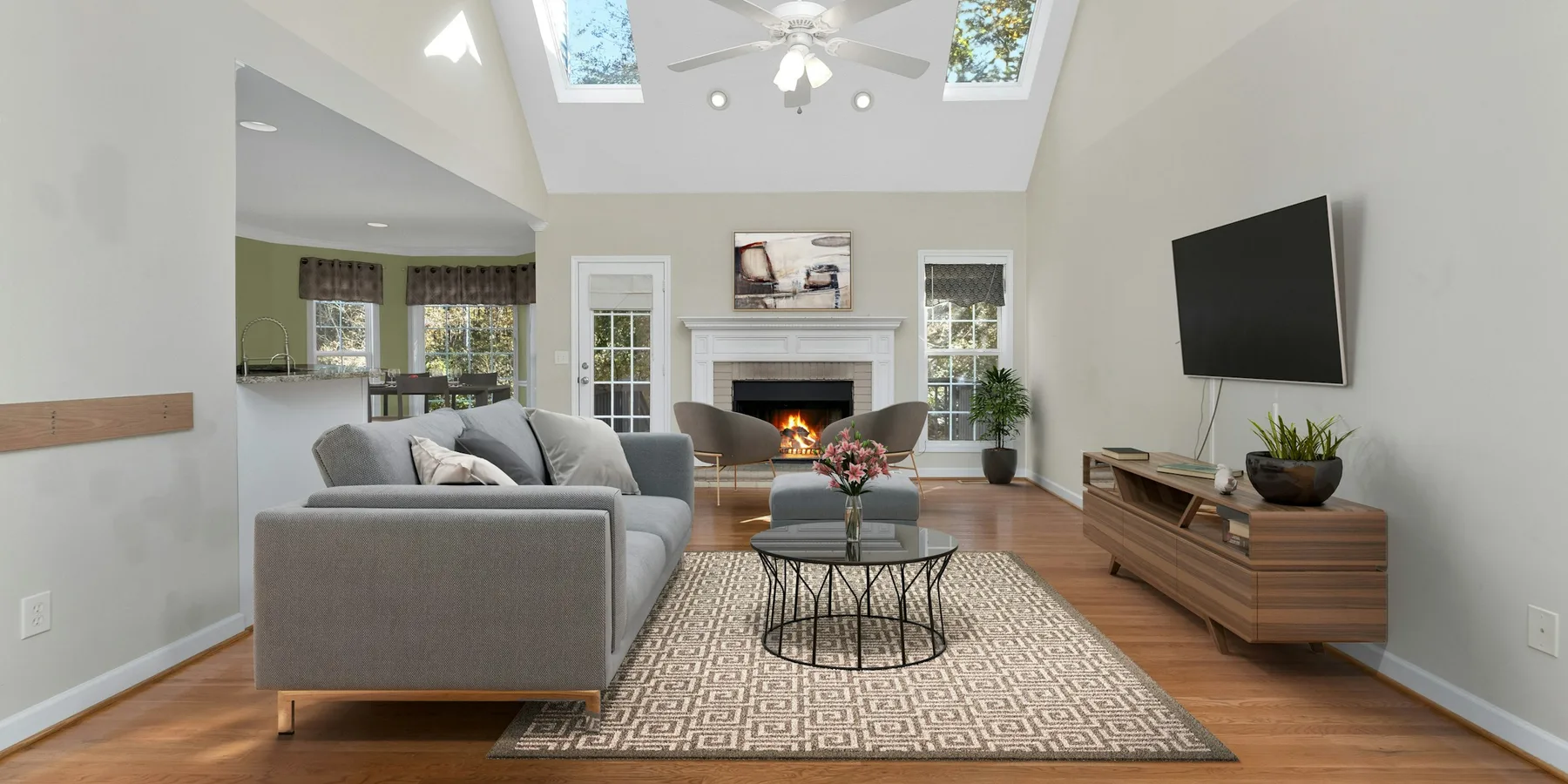 Living room with a wood floor running from the fireplace through to the kitchen