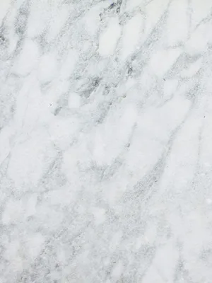 Close up of a white marble surface with soft gray veining