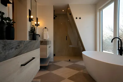 Remodeled bathroom with a freestanding tub, a stone top vanity and black fixtures