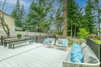 Backyard deck with light gray boards, built in benches and outdoor seating